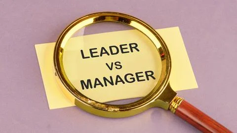 Leader vs manager is shown through a magnifying glass on yellow paper Stock Photos