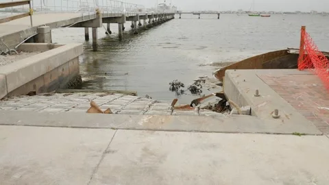 Leading lines to water Low angle view down a damaged rippled concrete boat ramp Stock Footage 291314523