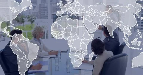 Leading presenter guiding five colleagues in suits at conference table, with map 库存照片