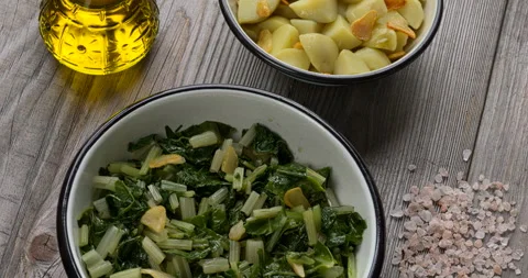 Leaf beet and boiled potatoes with fried garlic in bowls. Stock Footage 289321110