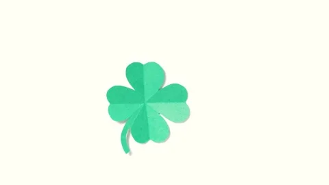 A leaf of clover cut out of paper is spinning on a white background. Stock Footage 169635766