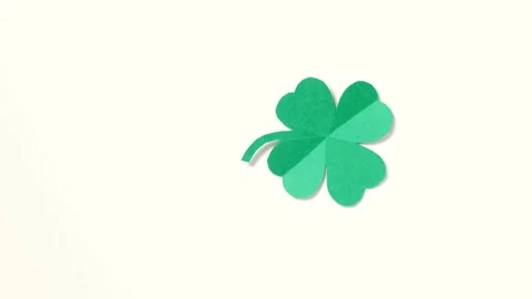 A leaf of clover cut out of paper is spinning on a white background. Stock Footage 169635896
