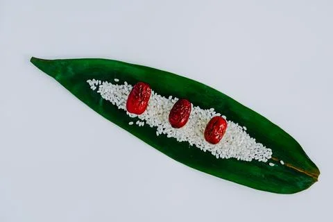 Leaf with rice and red berries on white background Stock Photos