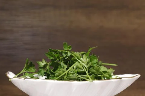 Leaf-shaped ceramic dish filled with fresh parsley. Stock Photos