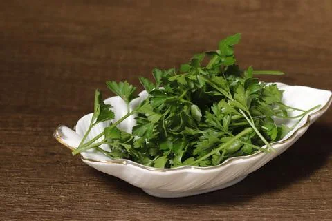 Leaf-shaped ceramic dish filled with fresh parsley. Stock Photos