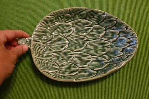 Leaf-shaped ceramic plate on a green placemat 스톡 사진