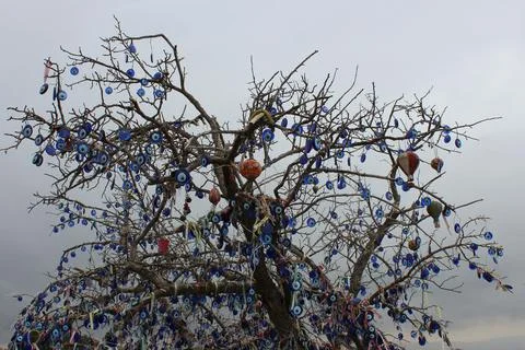 A leafless tree hung with souvenirs in the form of balloons and blue glass ba Stock Photos