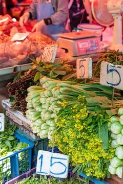 Leafy vegetables stacked vertically at Bangkok market stall Stock Photos
