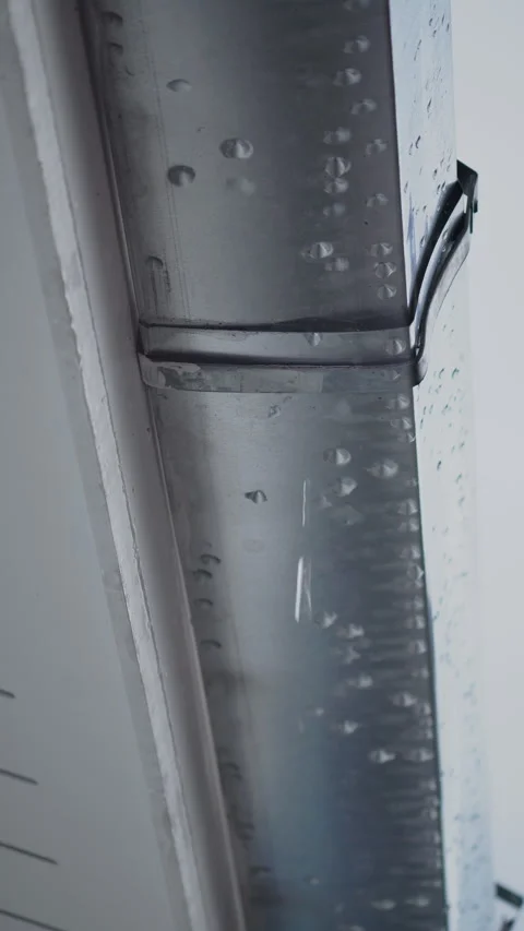 Leaking galvanized roof gutter joint with water dripping from worn-out seal Video stock 320389333