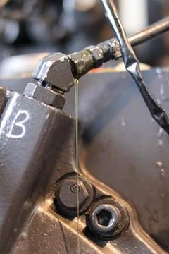 Leaking Hydraulic Fitting and Fluid Stream. 库存照片