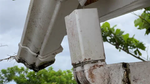 Leaking rain gutter downspout tilt up reveal disconnected pipe Stock Footage 327841295