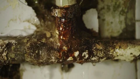 Leaking rusty metal water pipe. Close-up of an aged metal pipe with corrosion. Stock Footage 321371914