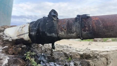 Leaking Water Pipe Dripping from Damaged Rusty Joint with Emergency Repair Stock Footage 344809414