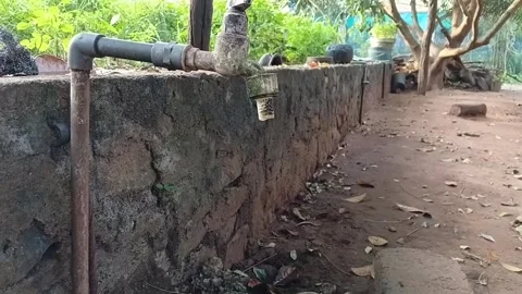 Leaking Water Tap in Dirty Backyard - Concept of Water Wastage and Poor Hygiene Video stock 327551313