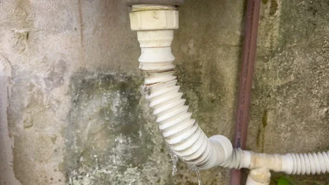 Leaking White Pipe on Weathered Concrete Wall Stock Footage 335459111