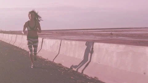 A Lean Female Runner Jogs Along An Old Desert Highway In Early Morning. Stock Footage 50954896