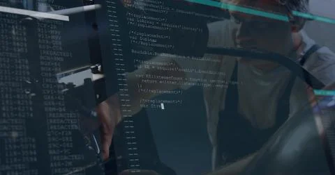 Leaning coder wearing dark apron, glasses reviewing code on monitors, glass 스톡 사진