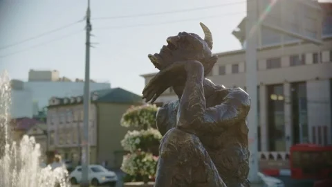 Leaning on hand devil statue against building on city street Video stock 219471582