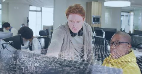 Leaning red-haired dev pointing at screen in office showing data overlay, Stock Photos