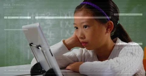 Leaning student reading code on tablet in classroom, with charging cable, Foto stock