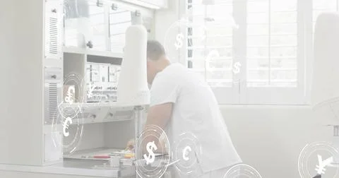 Leaning tech working over bench in clinical lab, white tee, handling control Photos