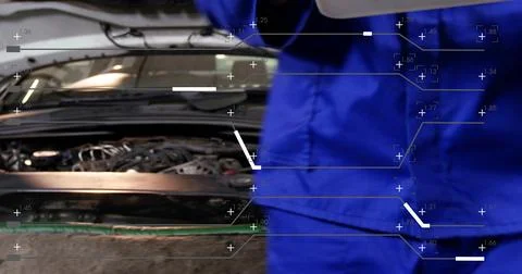 Leaning technician inspecting open hood and engine wiring at garage, wearing Stock Photos
