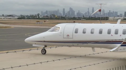 Learjet at airport with city backdrop Video stock 207662961