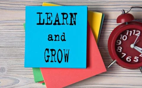 LEARN and GROW - words on note paper on wooden light background Stock Photos