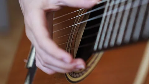 Learn basic guitar strumming techniques at home 스톡 동영상 332467748