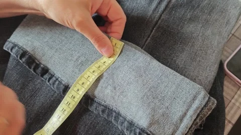 Learn how to shorten jeans by cutting and sewing them step by step Stock Footage 340462807