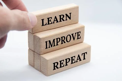 Learn, improve and repeat text on wooden blocks with white cover background.. Foto stock