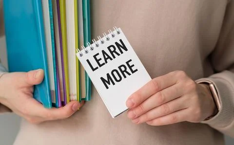 Learn More Text on notebook in hands with books, concept of education Stock Photos