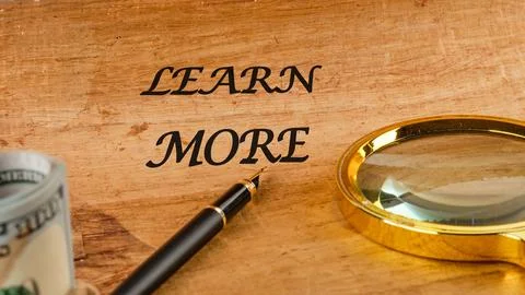 LEARN MORE text on papyrus in a composition with a fountain pen, a magnifying Stock Photos