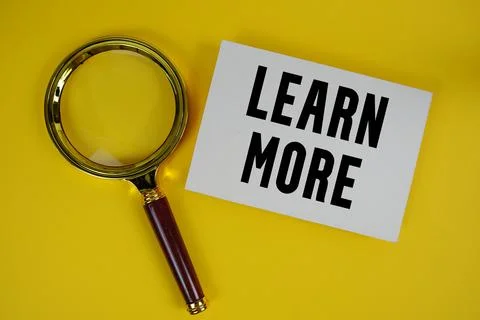 Learn More text written on paper with magnifying glass Stock Photos