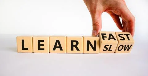 Learn slow or fast symbol. Businessman turns wooden cubes and changes words ' Stock Photos
