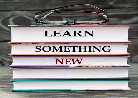 LEARN SOMETHING NEW - words are written on books on a dark background Stock Photos