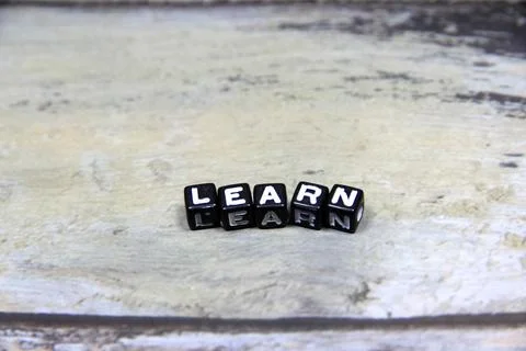 "LEARN" text or message short word letter on black plastic block with wood .. Stock Photos