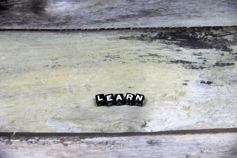 Learn wording  or text on black small beads with grey background.Copy space.. Stock Photos
