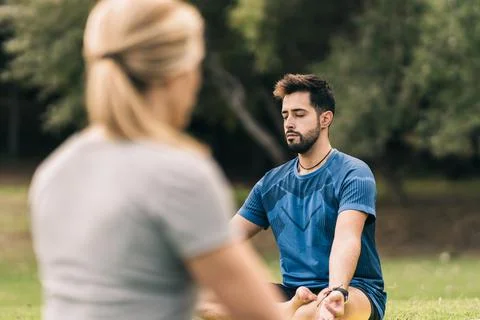 Learner and instructor doing yoga in a park Stock Photos