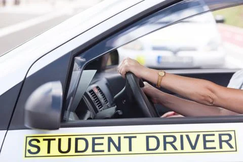 Learner driver holding steering wheel during driving lesson Stock Photos