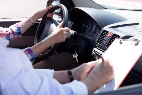 Learner driver student driving car with instructor. Stock Photos