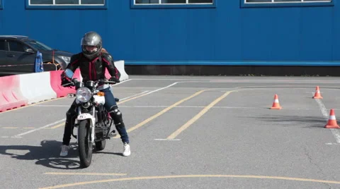 Learner motorcyclist trying to start driving on motorbike in driver school Stock Footage 66518216