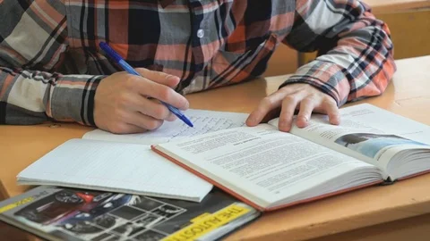 Learner writes the text in a notebook on a lesson Stock Footage 71606161