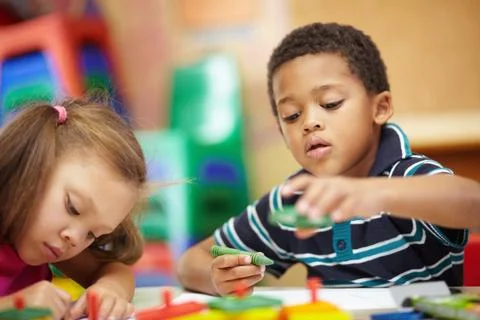 Learning and developing. Pre-school ethnic boy and girl scribbling and drawing Stock Photos