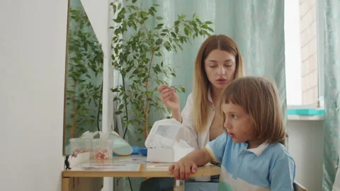 Learning and laughter: therapist in white, child explore language. Office Stock Footage 272945239