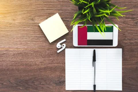 Learning Arabic, a smartphone with the flag of the UAE and a notebook for w.. Stock Photos