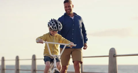 Learning, bicycle and proud dad teaching his young son to ride while wearing a Video stock 203997311