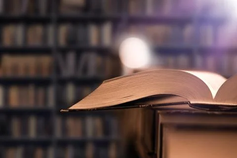 Learning from books in the library. Open book in college library, bookshelf in 스톡 사진