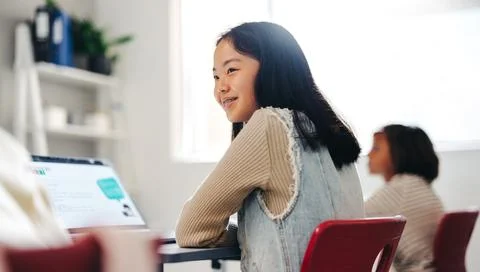 Learning to code: Girl sitting with a laptop in a computer science class Stock Photos
