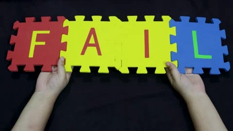 Learning concept fail spelled with kids puzzle mats on dark backdrop Stock Footage 319261763